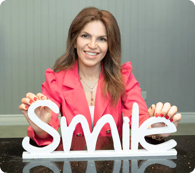 Dr. Neda Moezzi holding a Smile sign